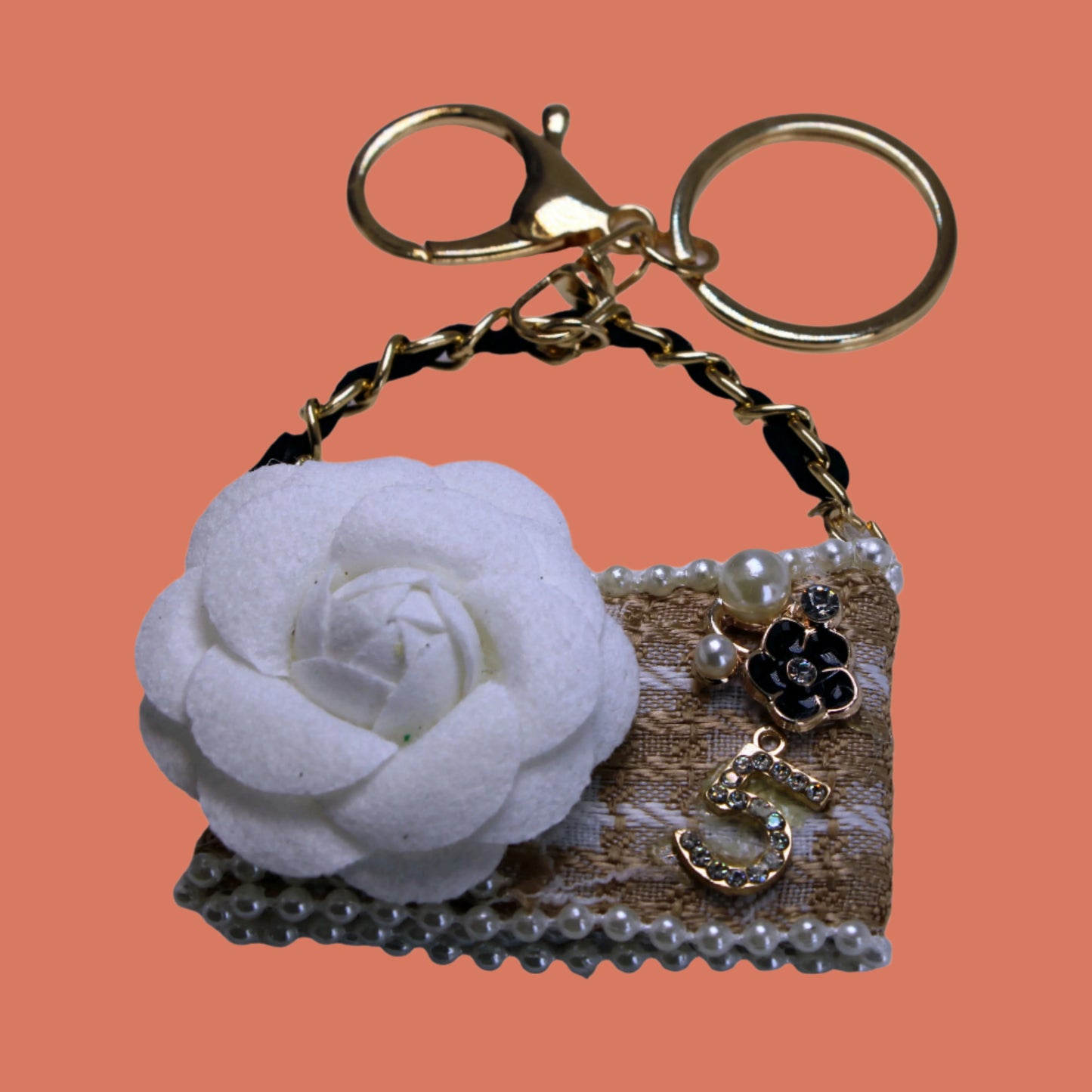 Keychain shaped like a purse with a white flower