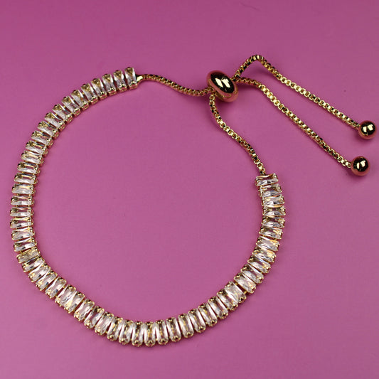 Gold beaded bracelet on a pink background