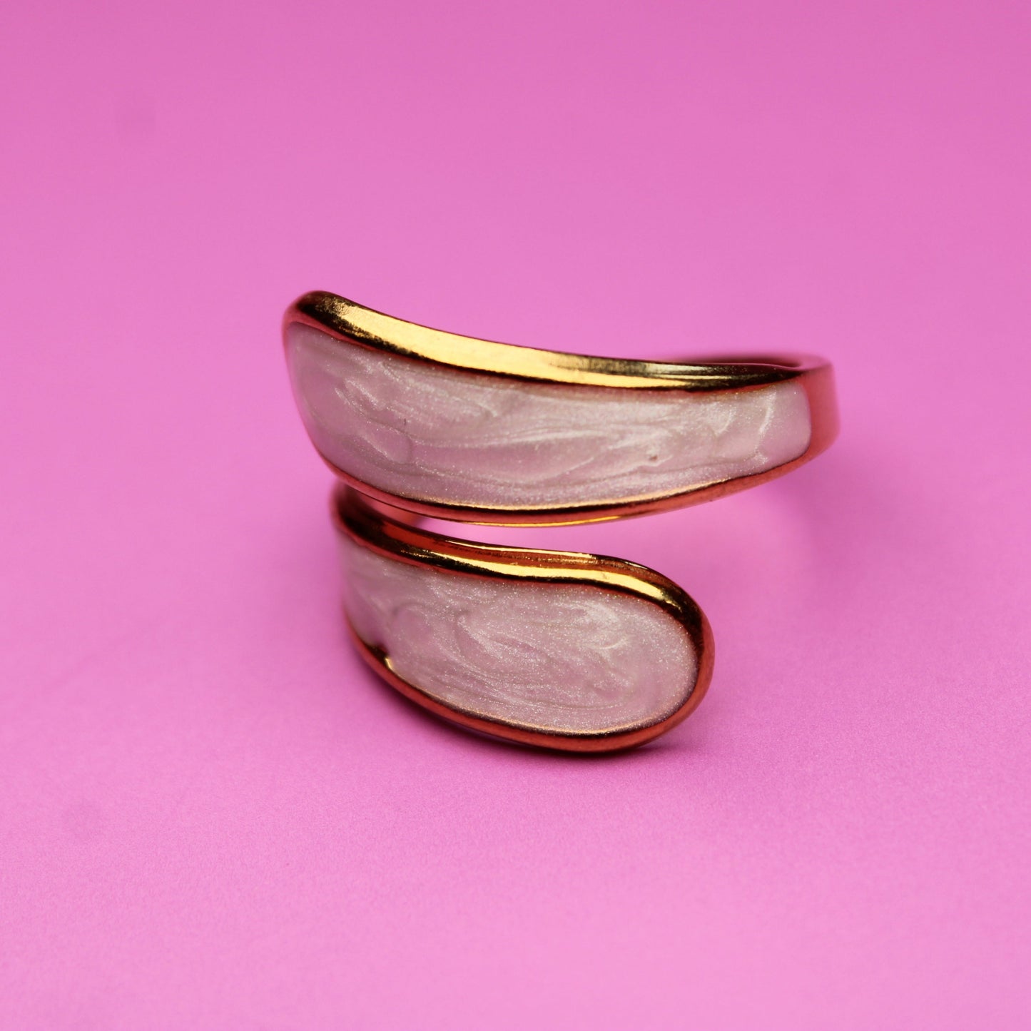 Gold and silver ring on a pink background