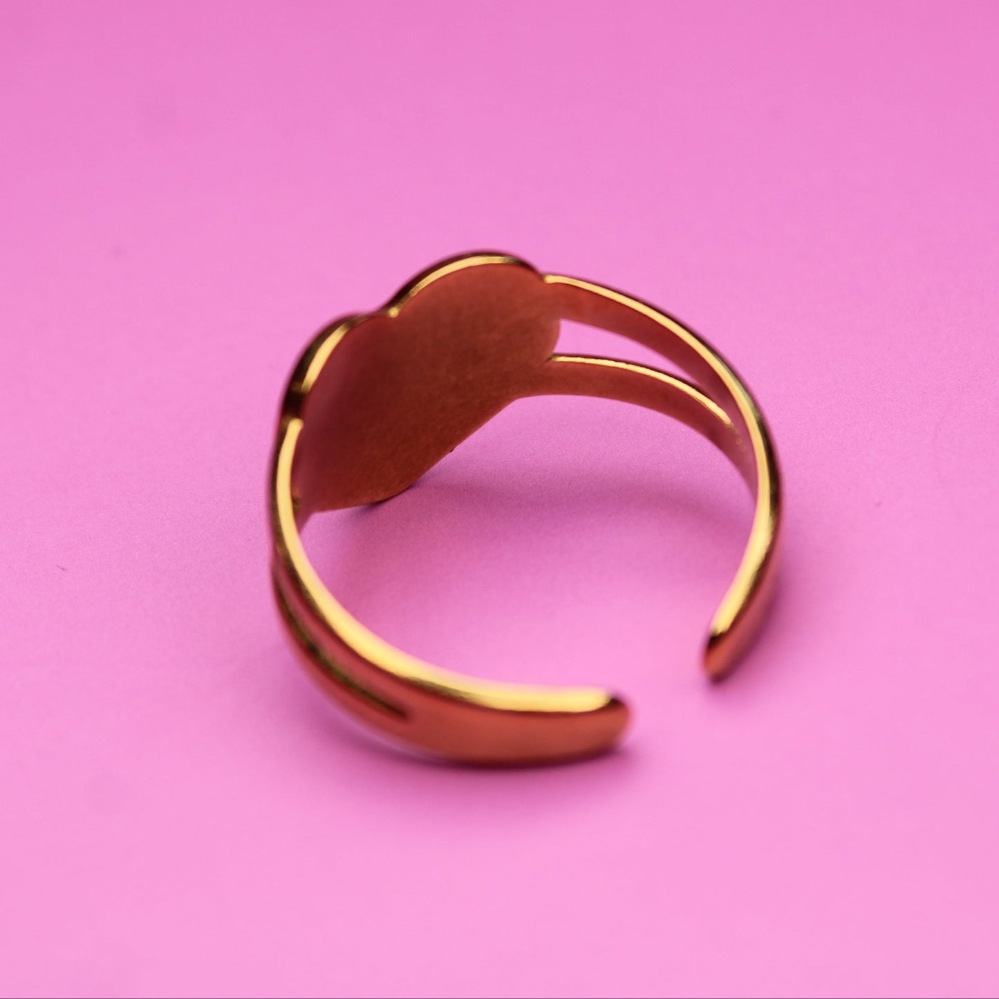 Gold ring on a pink background