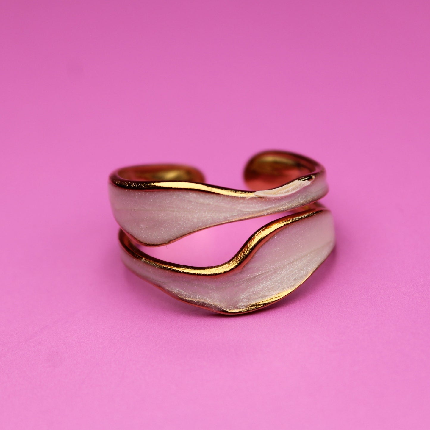 Gold and silver ring on a pink background