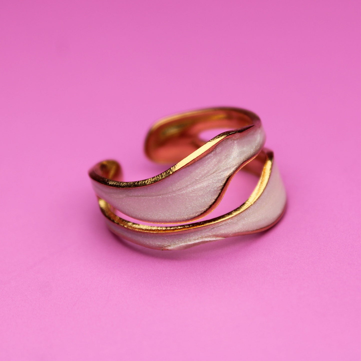 Gold and silver ring on a pink background