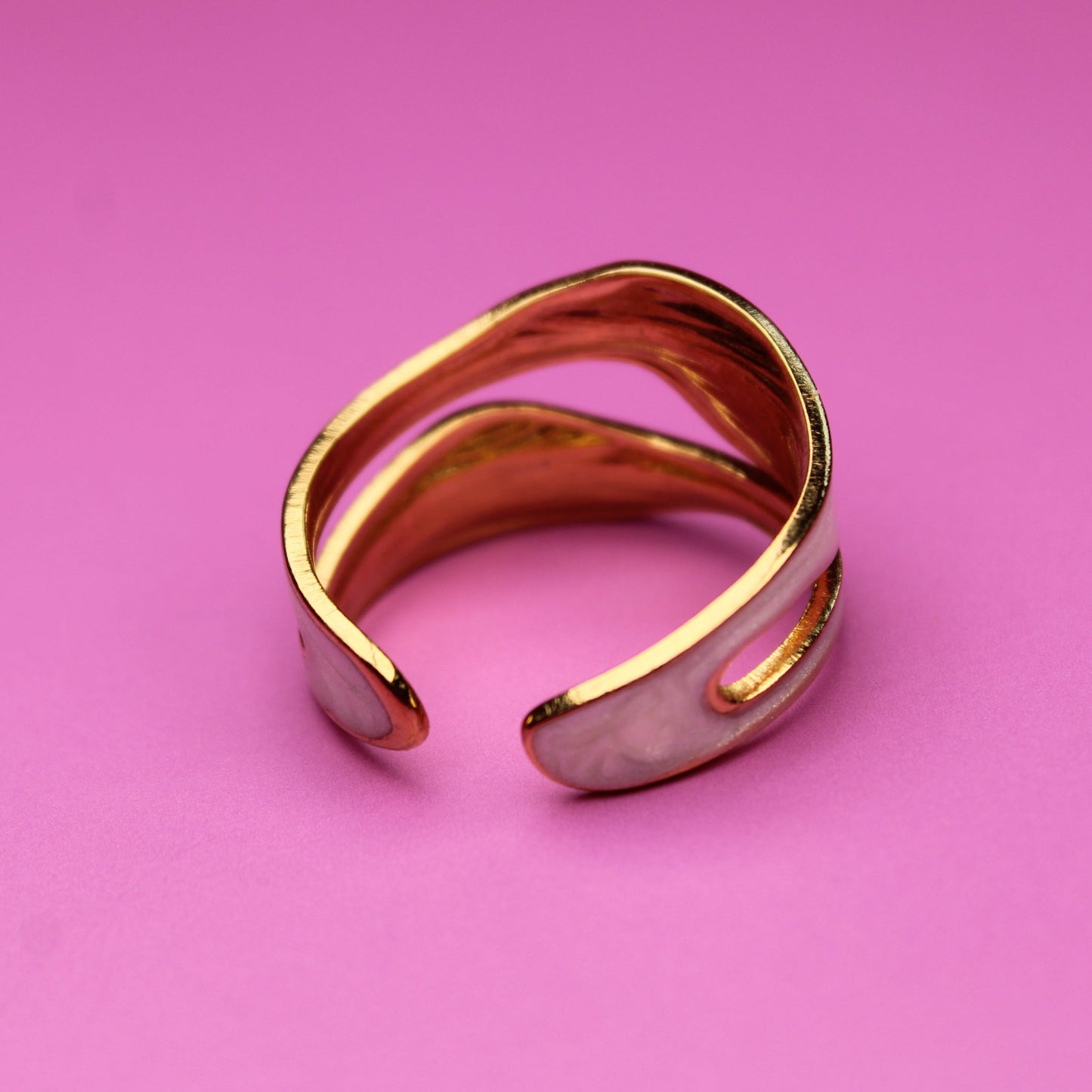 Gold bracelet on a pink background