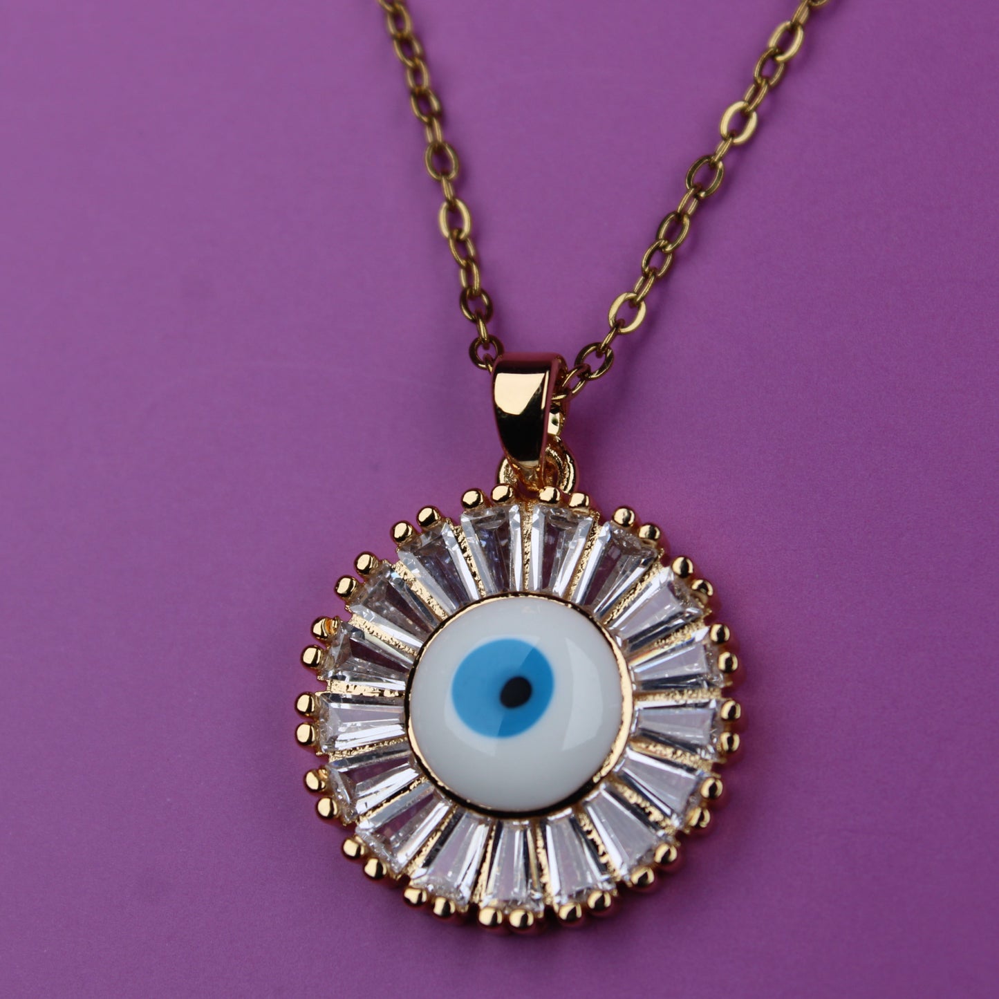 Necklace with a round pendant featuring an eye design on a purple background