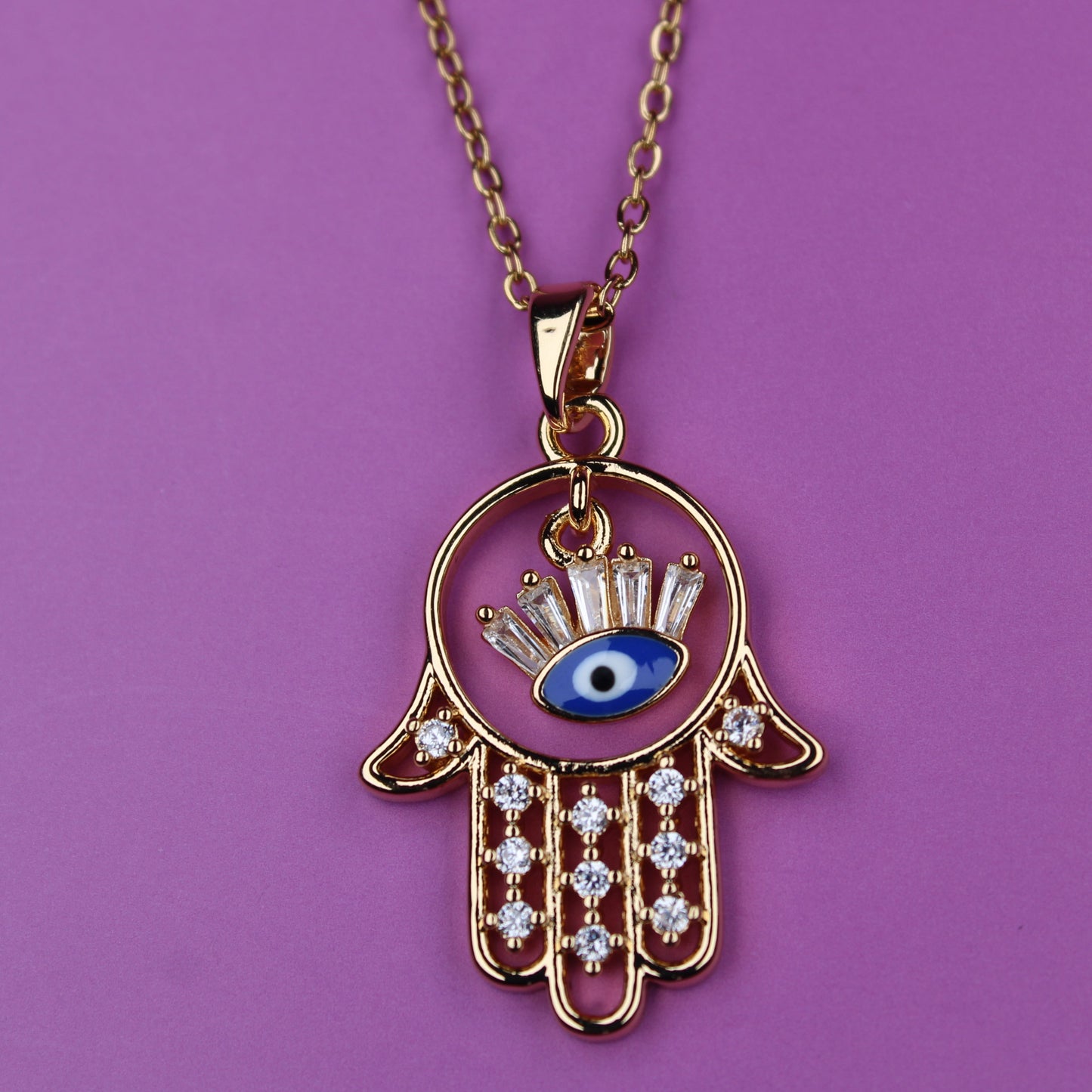 Necklace with Hamsa hand pendant featuring an eye design on a purple background