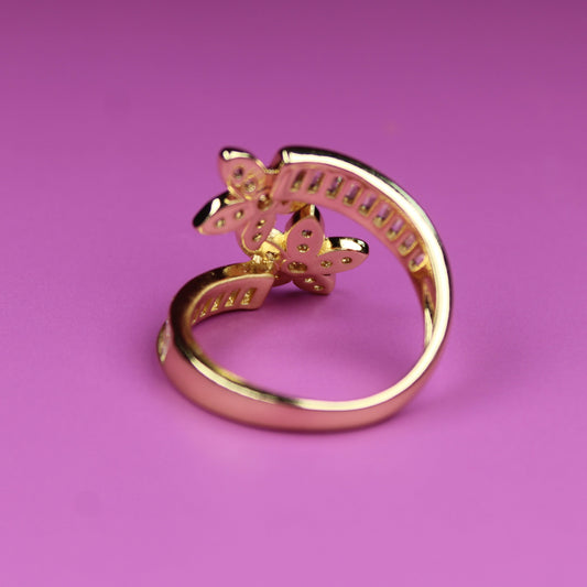 Gold ring with a star design on a pink background