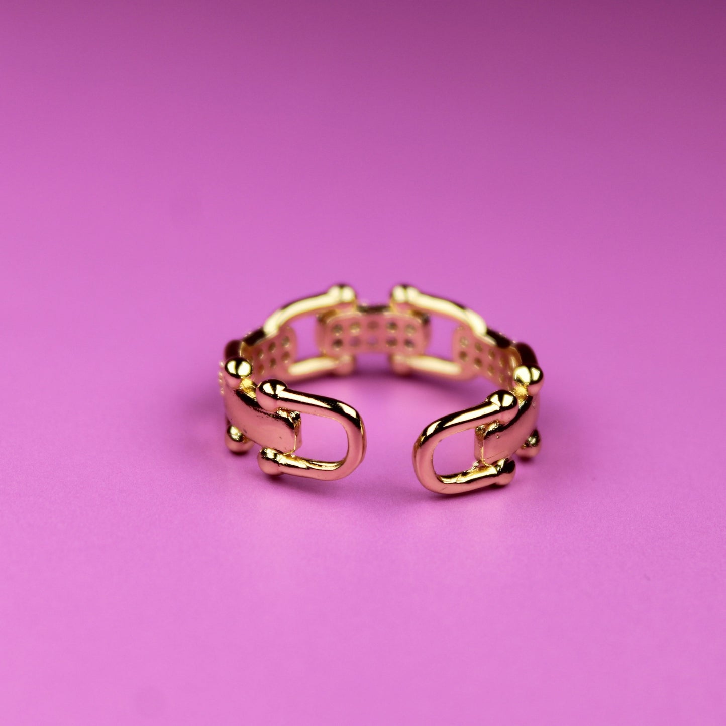 Gold ring on a pink background