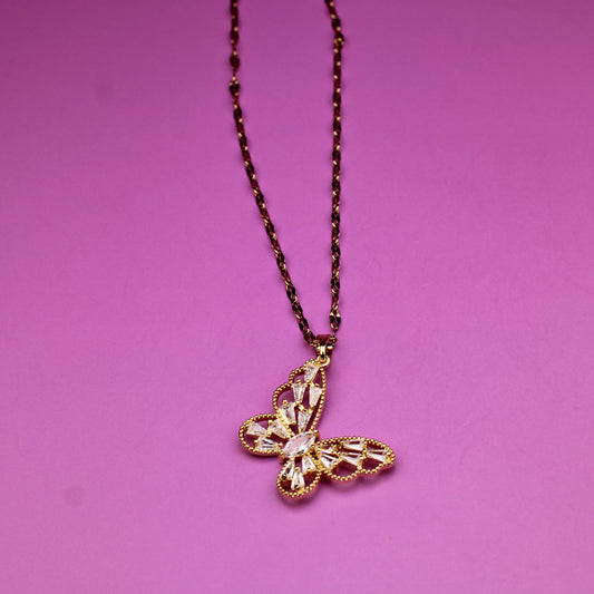 Gold butterfly pendant necklace on a purple background