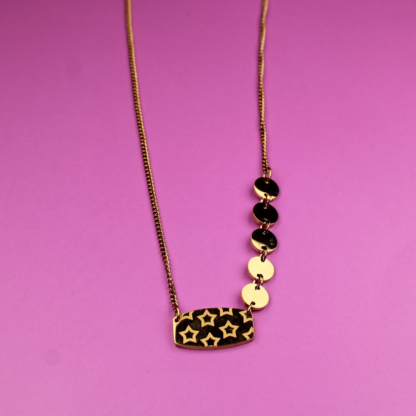 Necklace with leopard print pendant and black and gold beads on a pink background