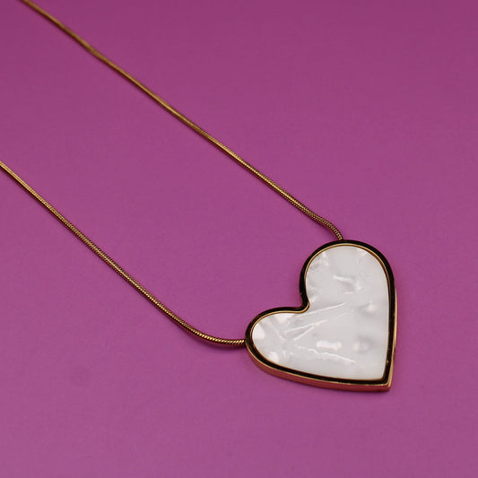 Heart-shaped necklace with a white heart pendant on a purple background