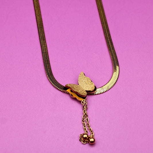 Gold necklace with a butterfly pendant on a pink background