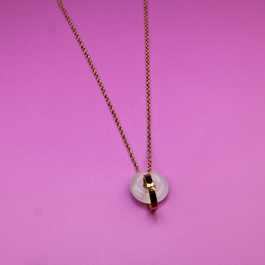 Necklace with a heart-shaped pendant on a pink background