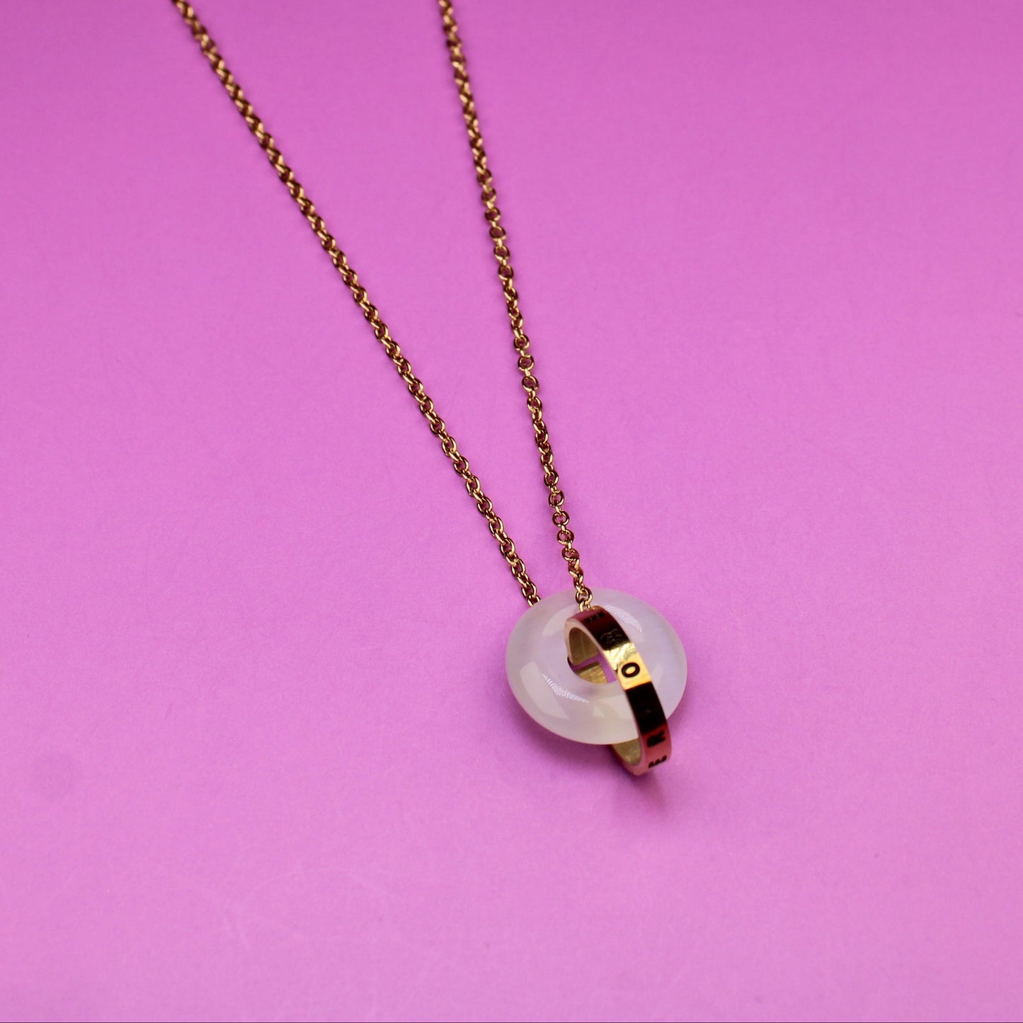 Necklace with a heart-shaped pendant on a pink background
