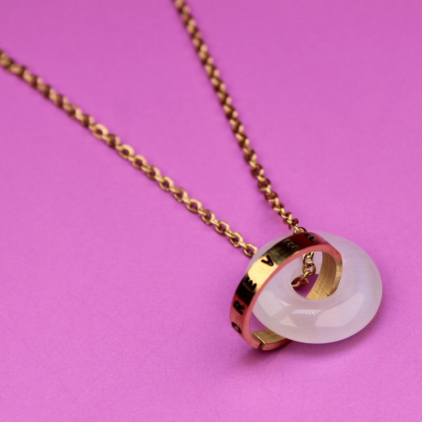Necklace with a round pendant on a pink background