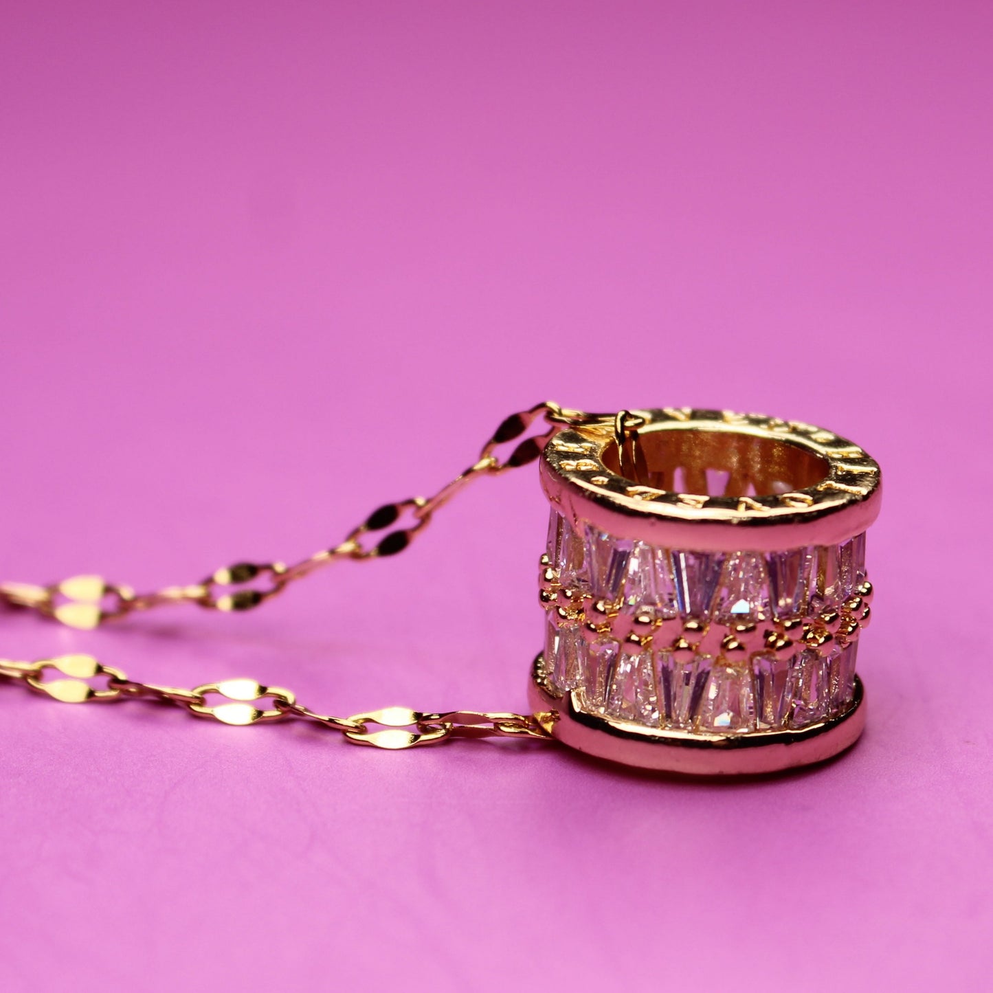 Necklace with a decorative ring pendant on a pink background