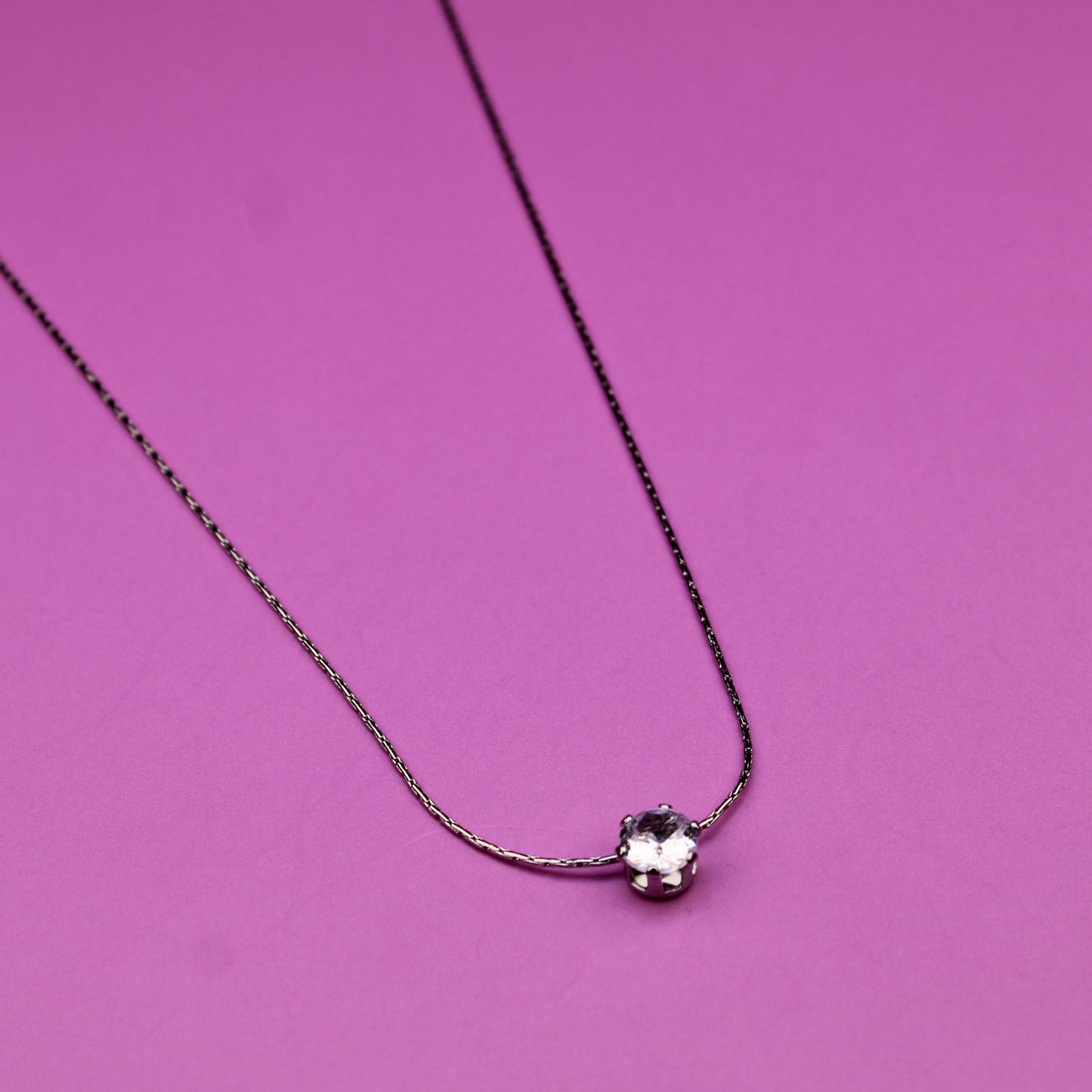 Necklace with a heart-shaped pendant on a pink background