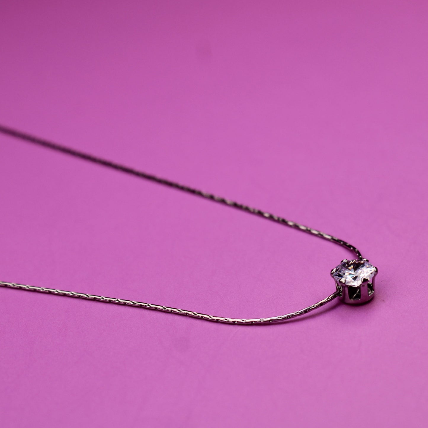 Necklace with a heart-shaped pendant on a pink background
