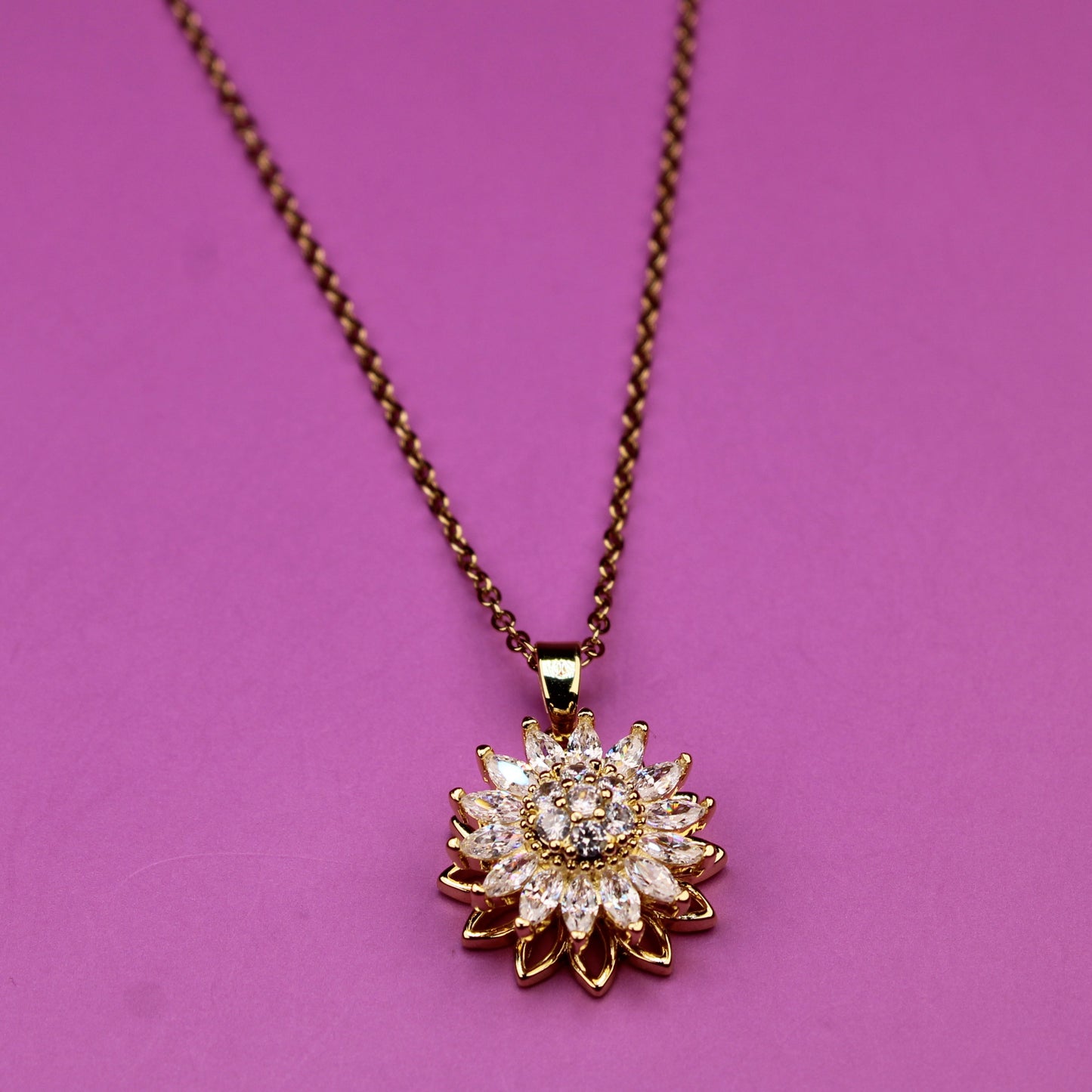 Necklace with a sunflower-shaped pendant on a pink background