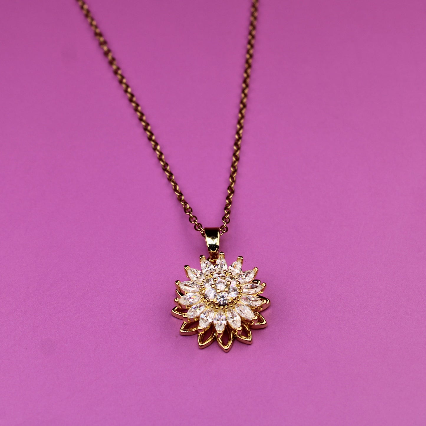 Necklace with a sunflower pendant on a pink background