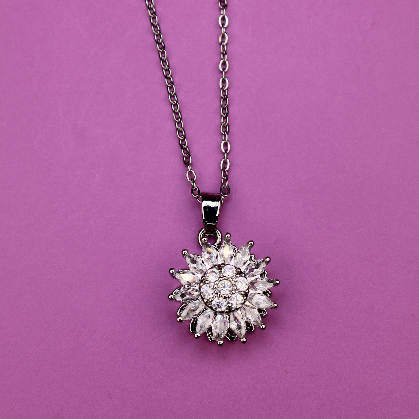 Silver necklace with a star-shaped pendant on a purple background