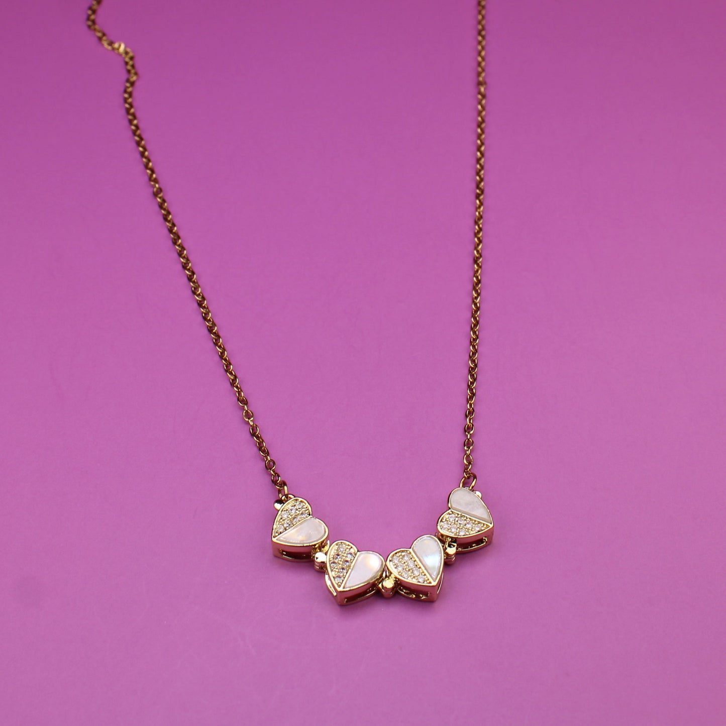 Necklace with heart-shaped pendants on a purple background