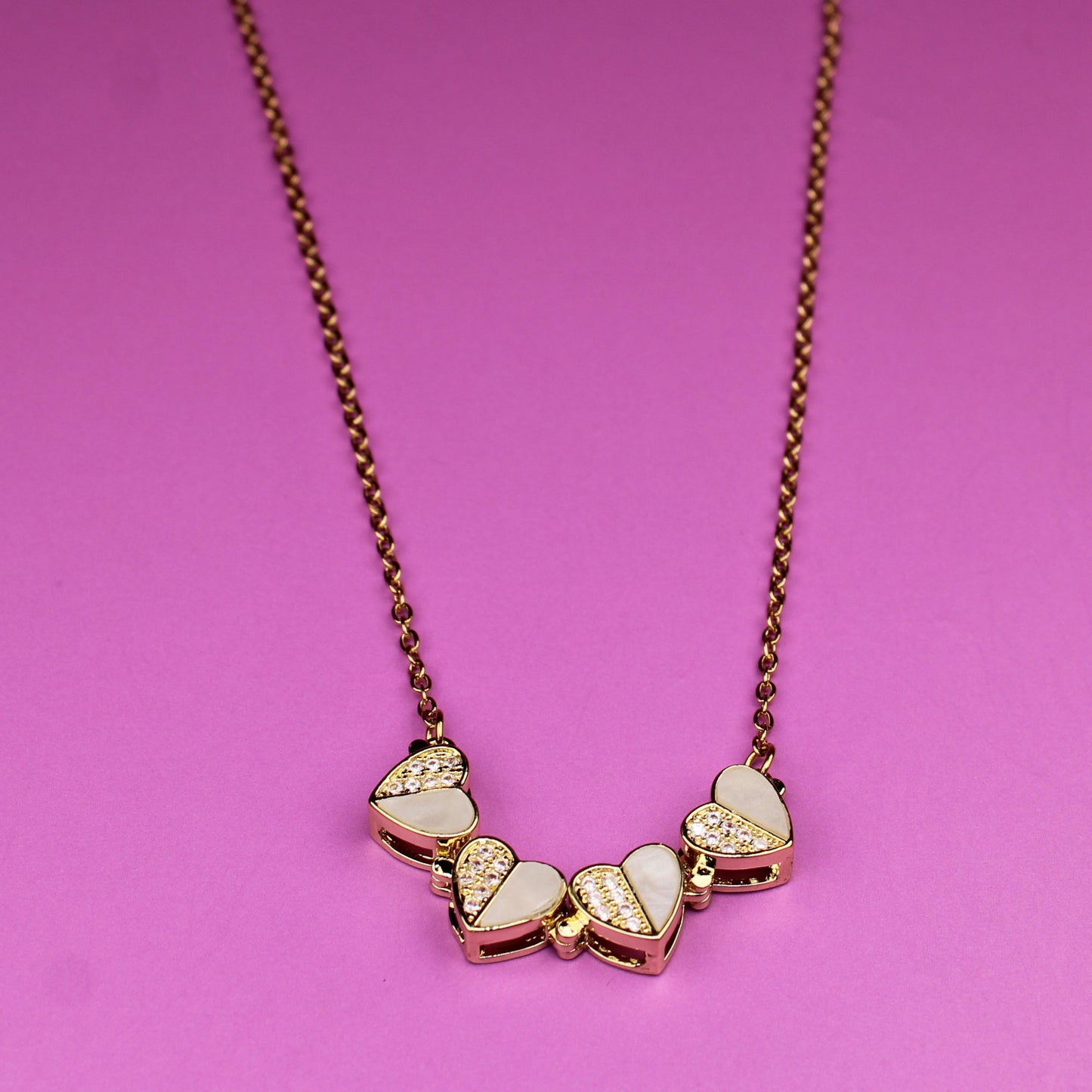 Necklace with heart-shaped pendants on a pink background