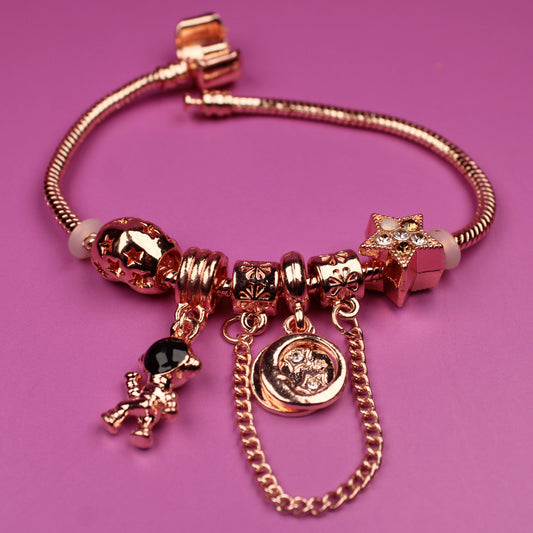 Rose gold bracelet with charms on a pink background
