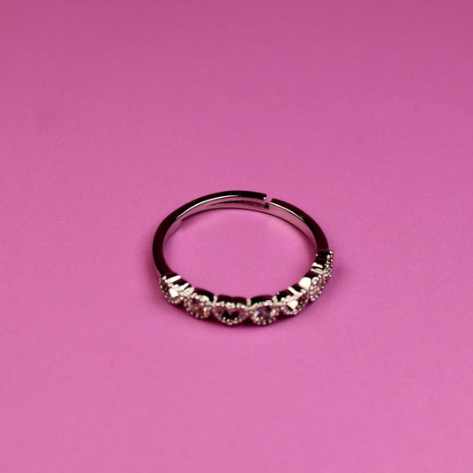 Silver ring with small stones on a pink background