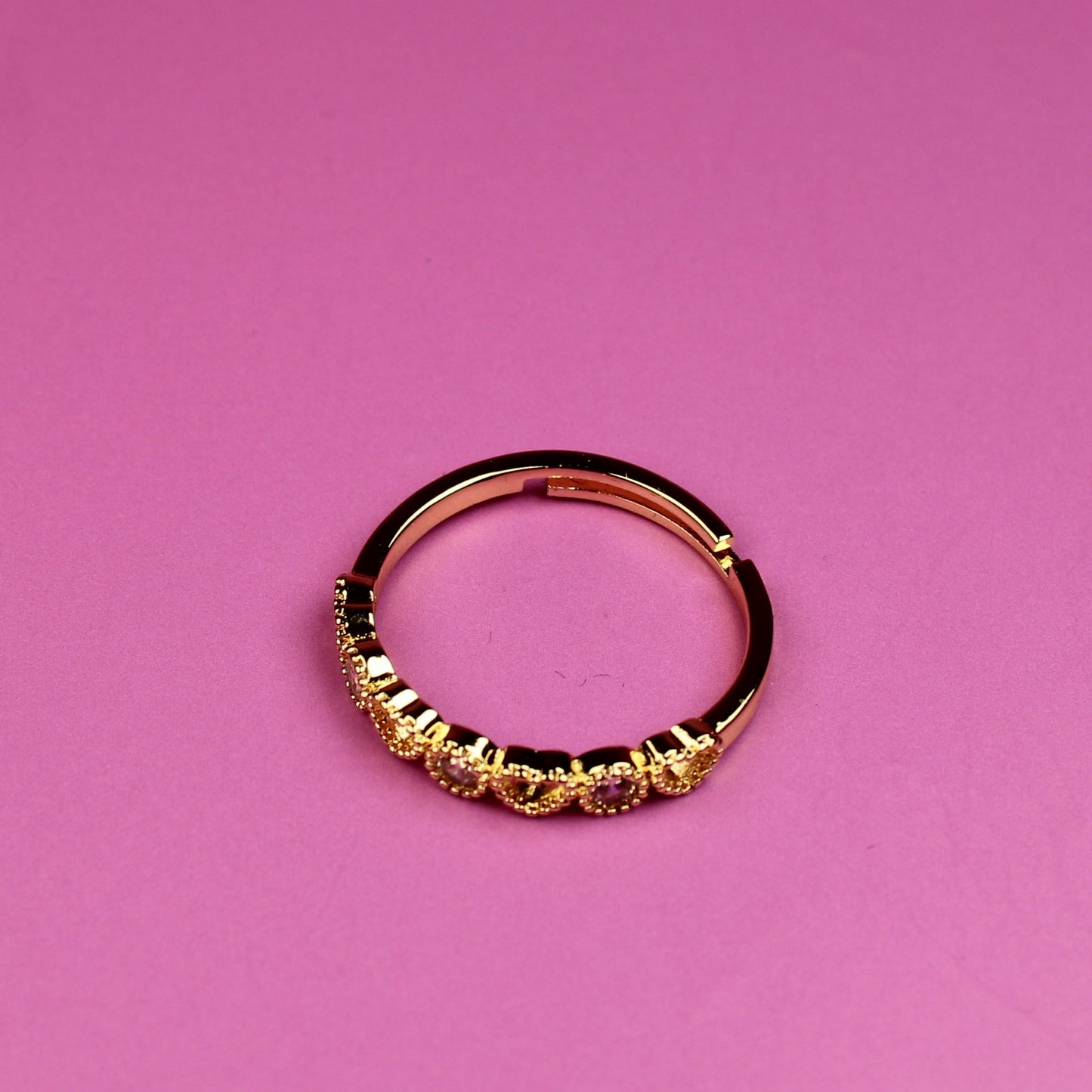 Gold ring on a pink background