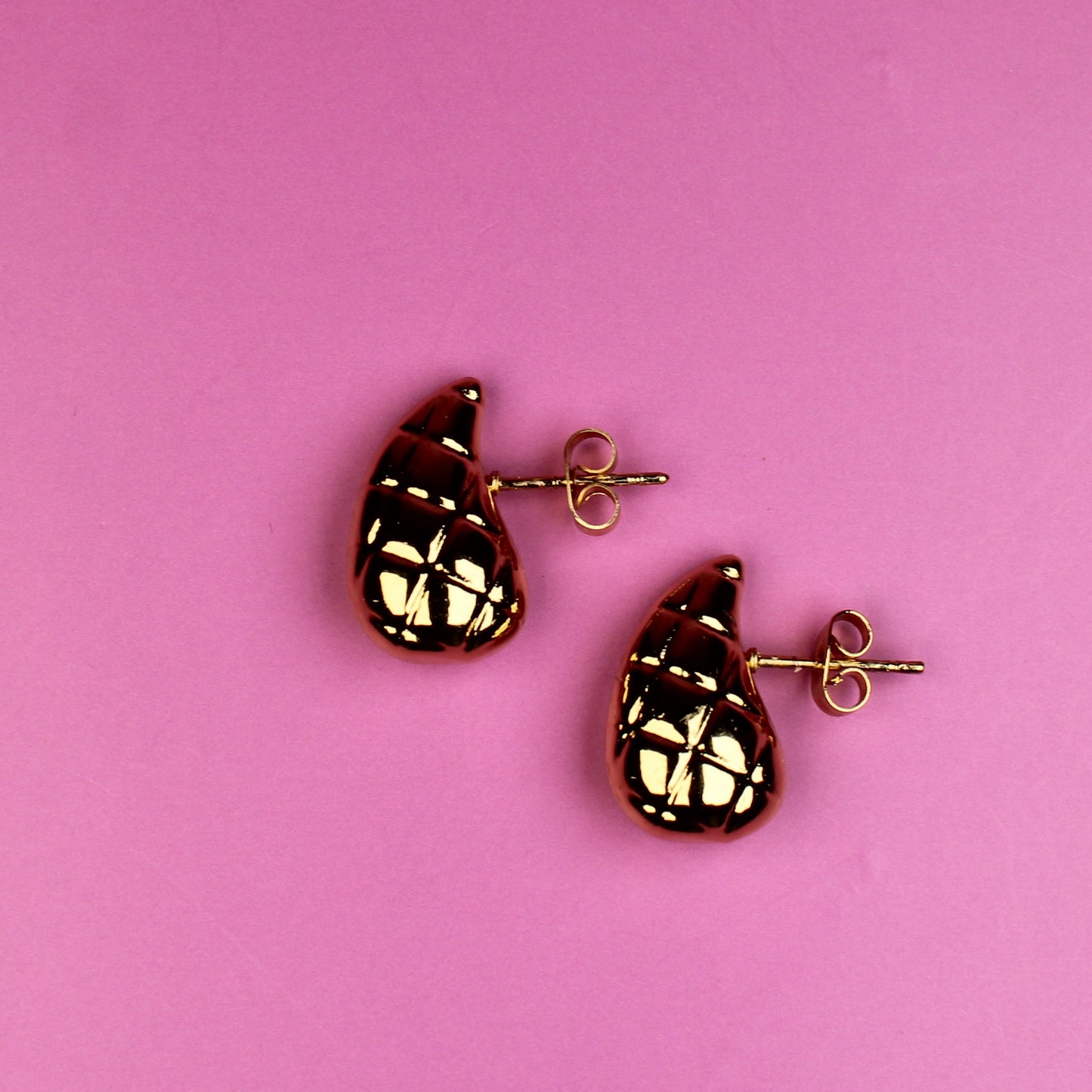 Pair of earrings on a pink background