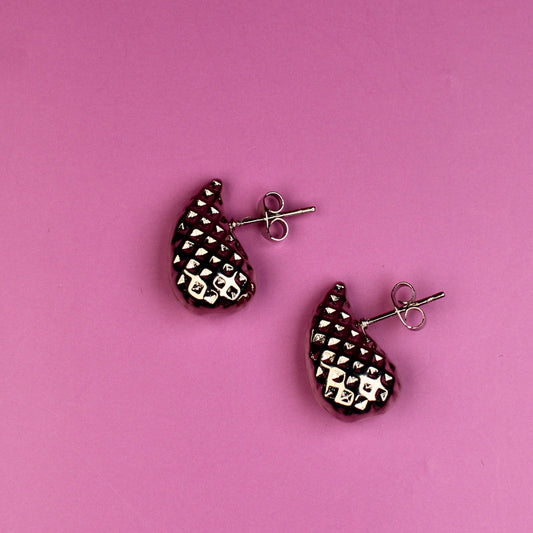 Pair of earrings on a pink background
