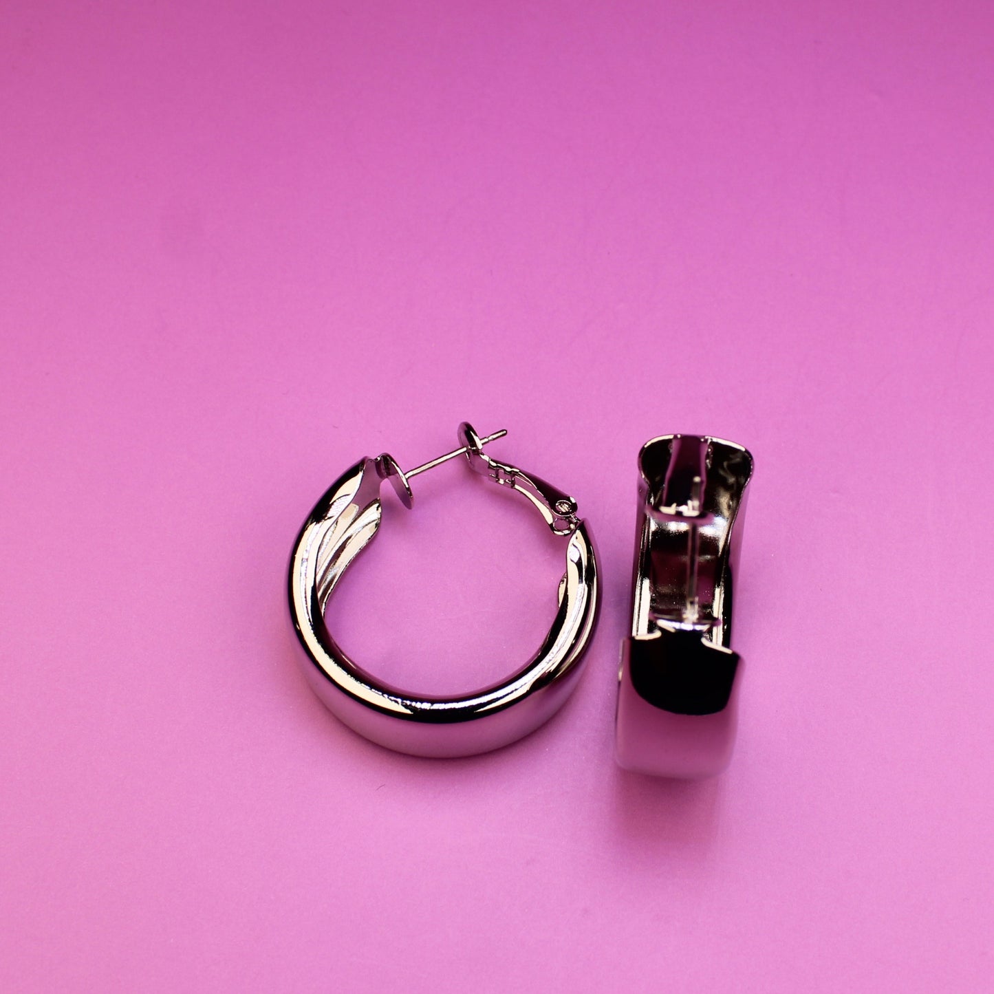 Pair of hoop earrings on a pink background