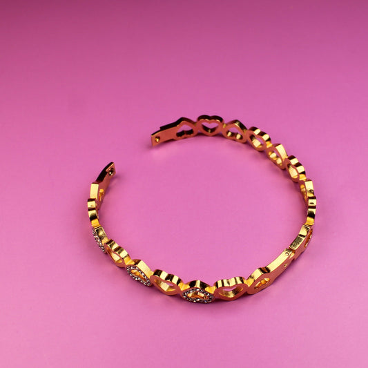 Gold bracelet on a pink background