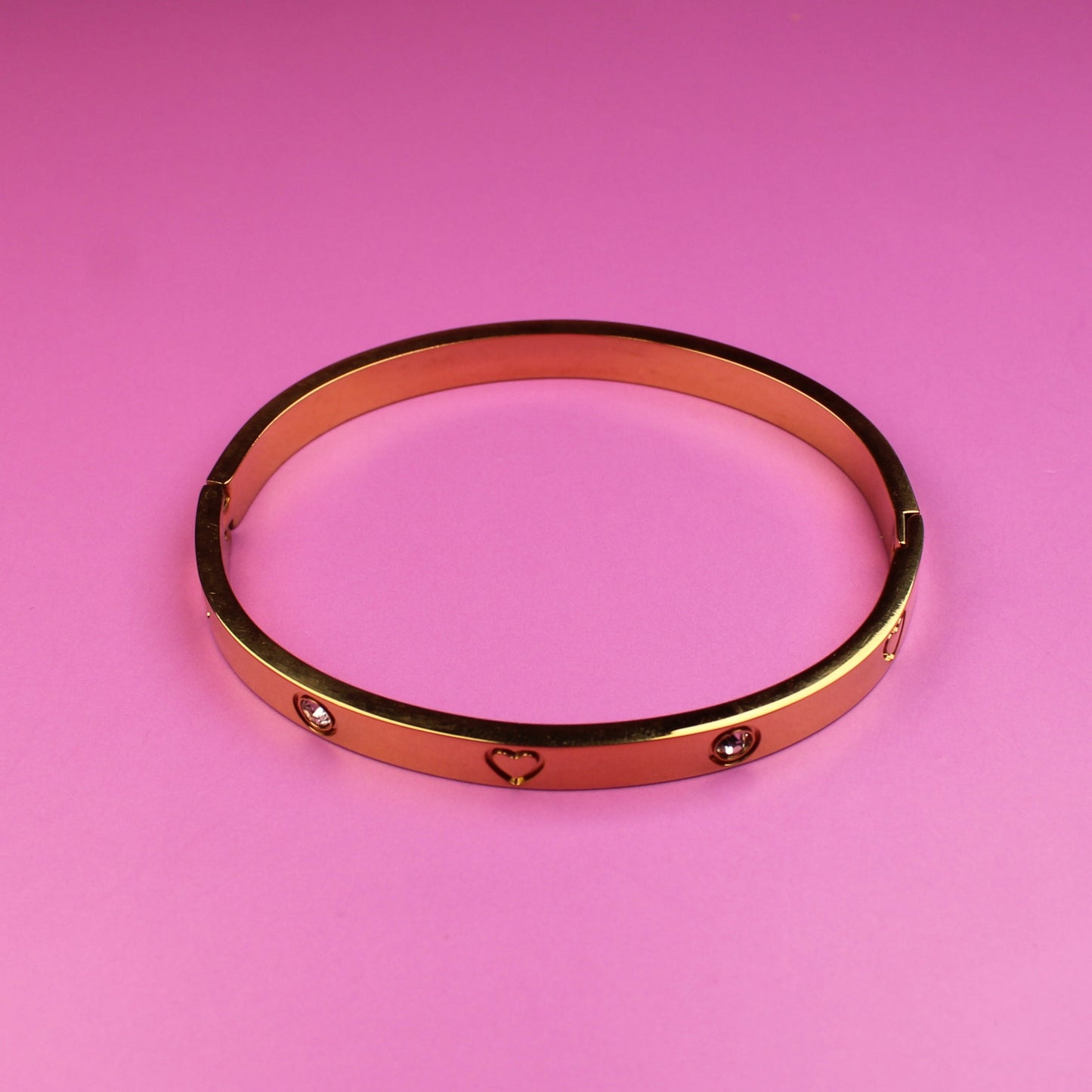 Rose gold bracelet on a pink background