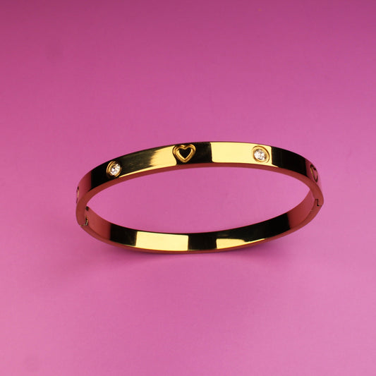 Gold bracelet on a pink background