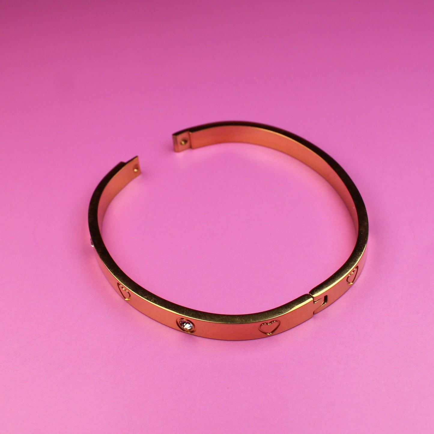 Rose gold bangle on a pink background