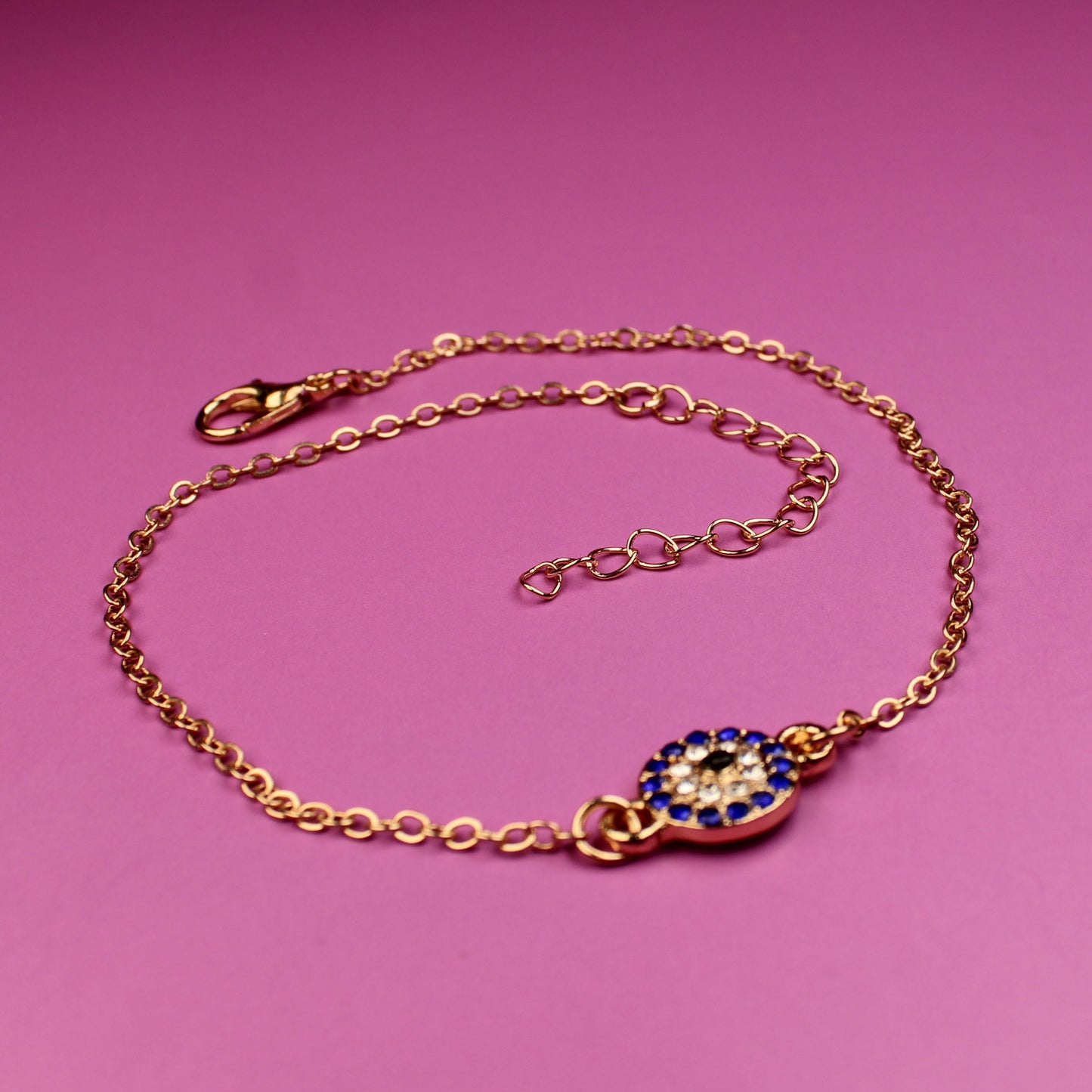 Gold bracelet with a clasp on a pink background