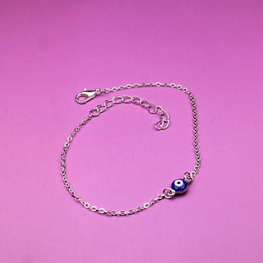 Silver bracelet with a blue charm on a pink background