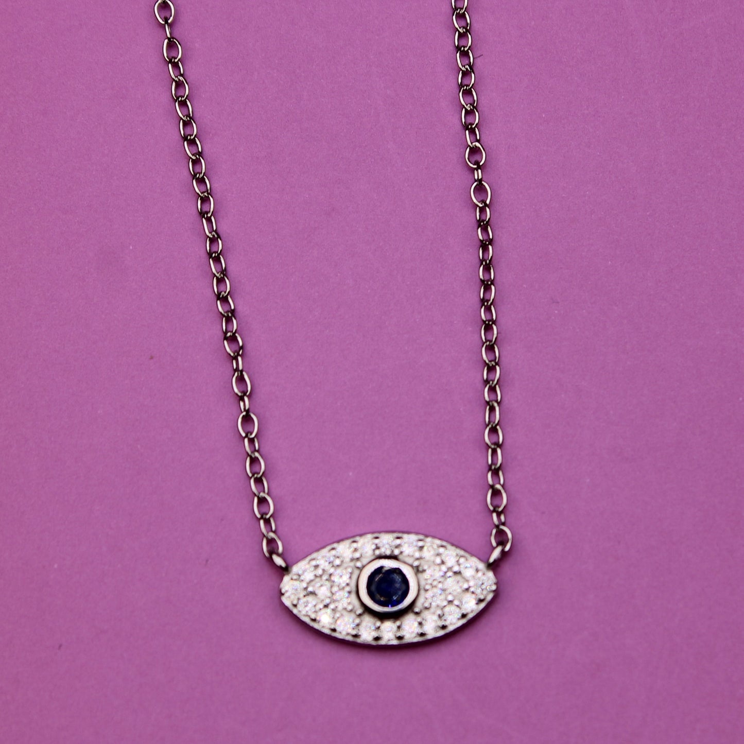 Necklace with an eye-shaped pendant on a purple background