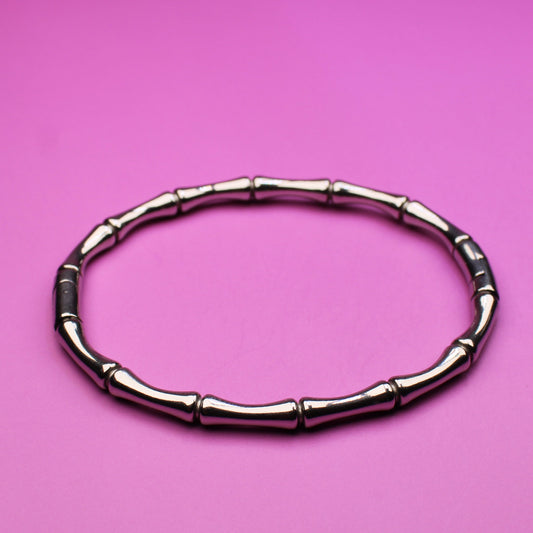 Bamboo-style bracelet on a pink background