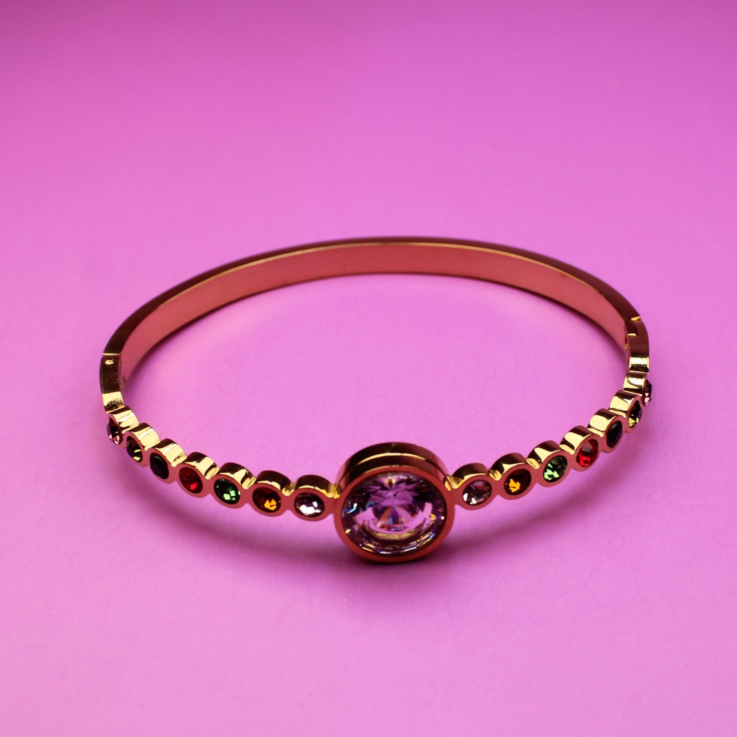 Gold ring with a pink gemstone on a pink background