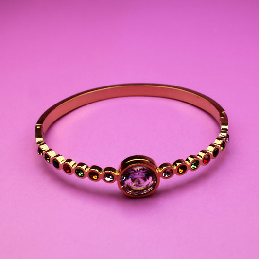 Gold ring with a pink gemstone on a pink background