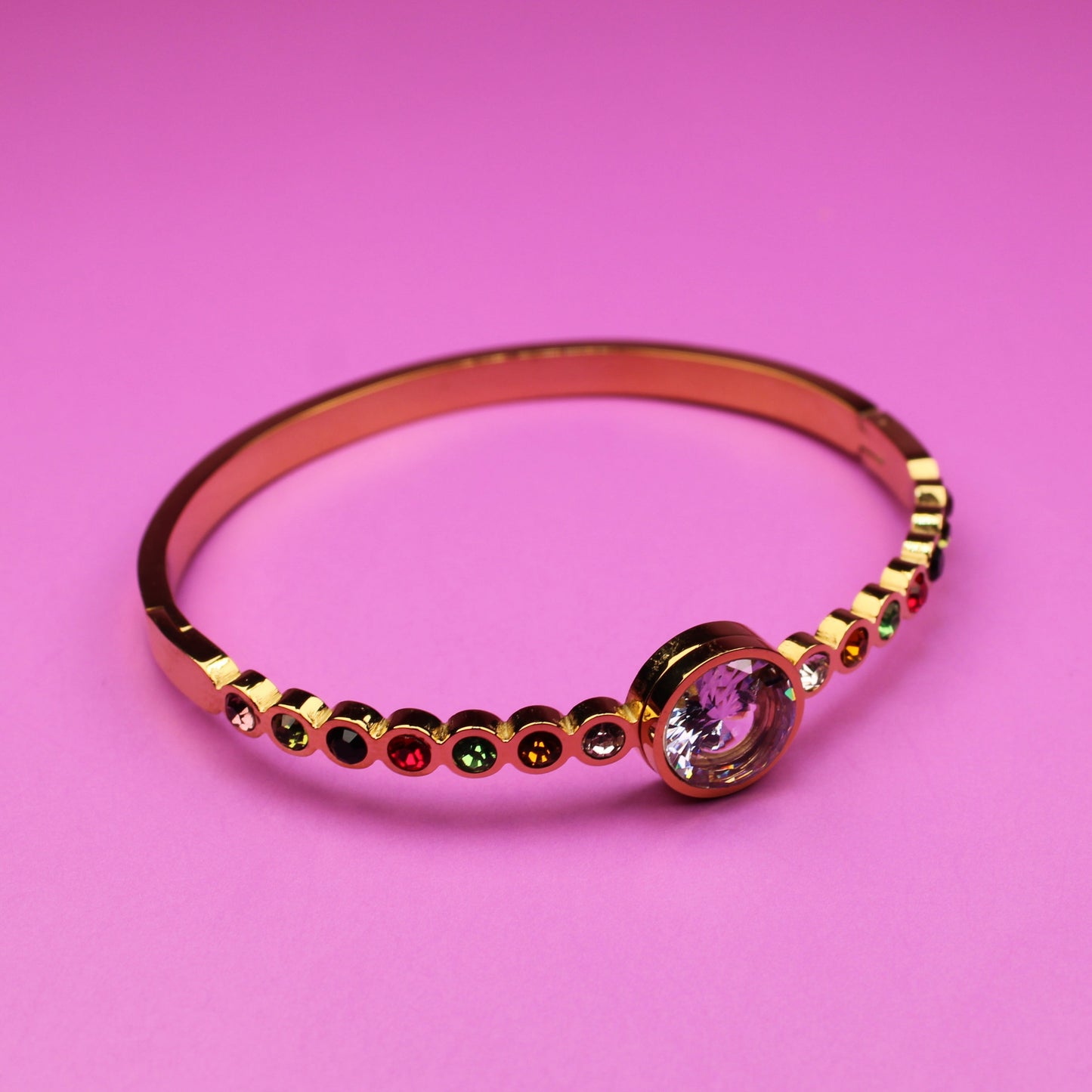Gold ring with a pink gemstone on a pink background