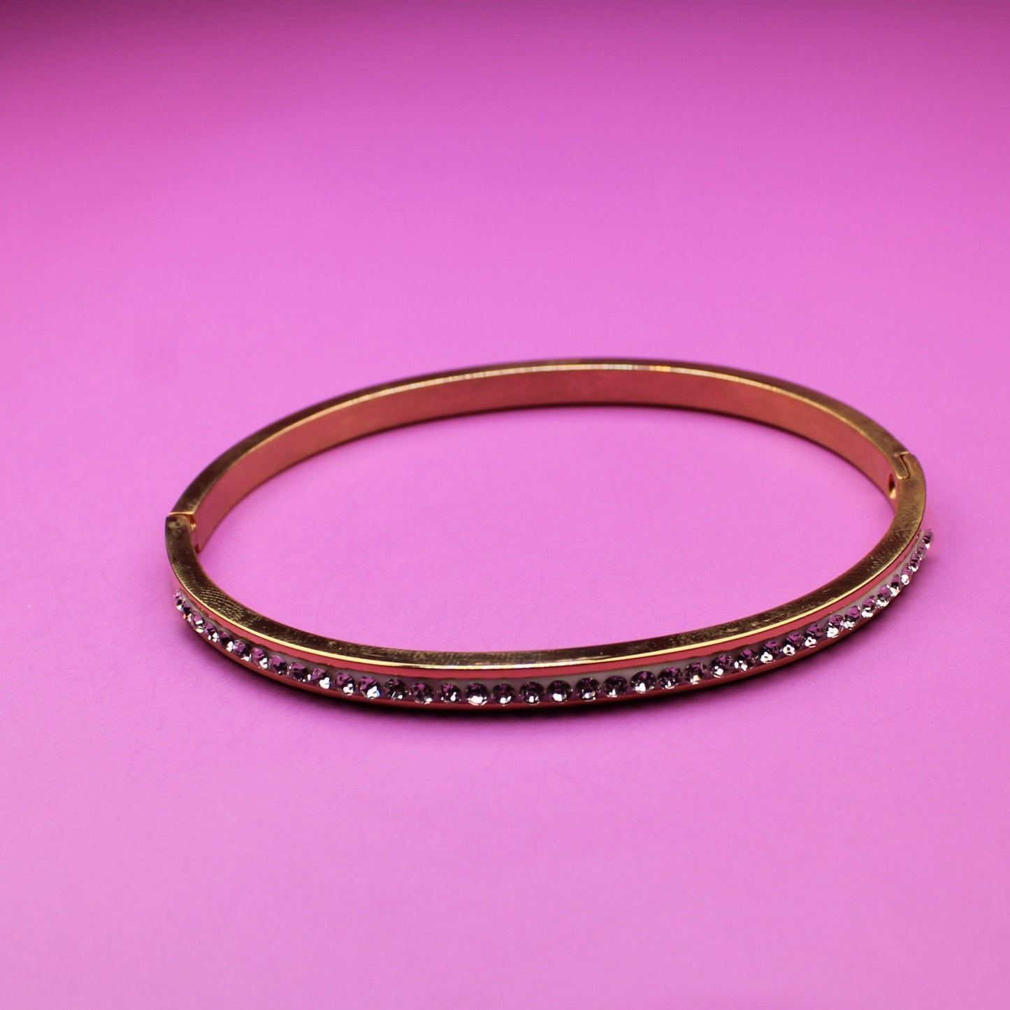 Bracelet with brown band and red stones on a pink background