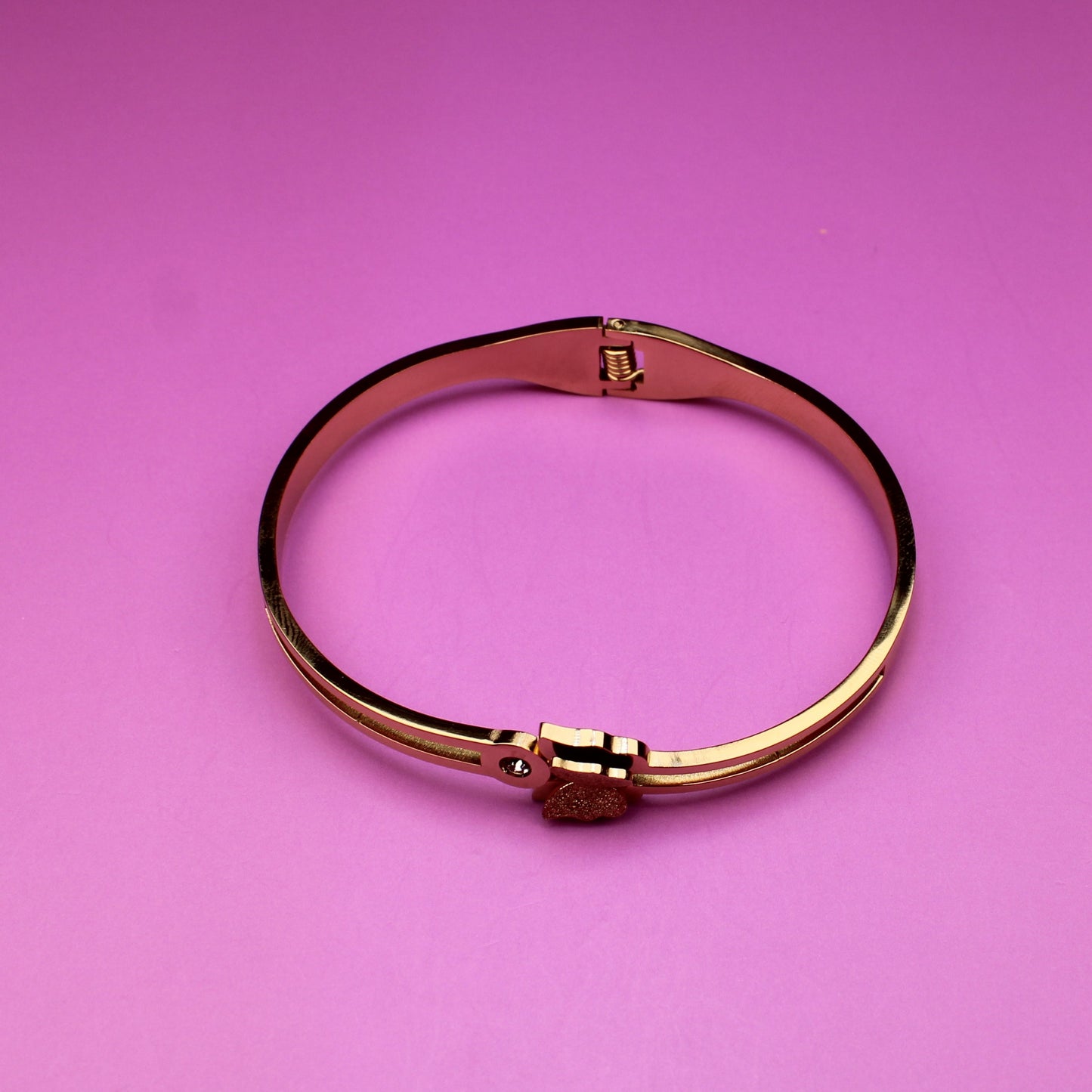 Gold bracelet on a pink background