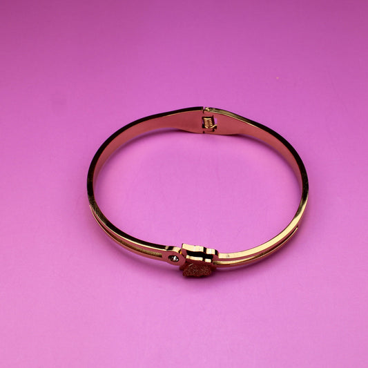 Gold bracelet on a pink background