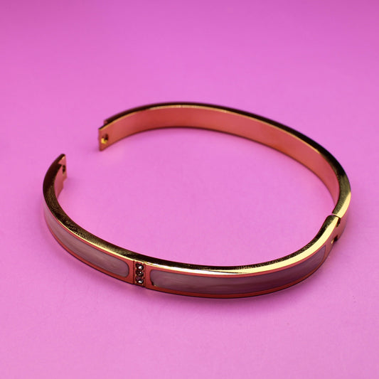 Rose gold bracelet on a pink background