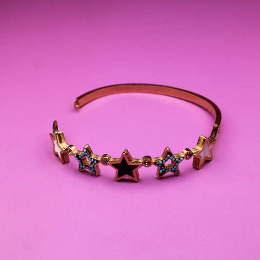 Bracelet with star-shaped charms on a pink background