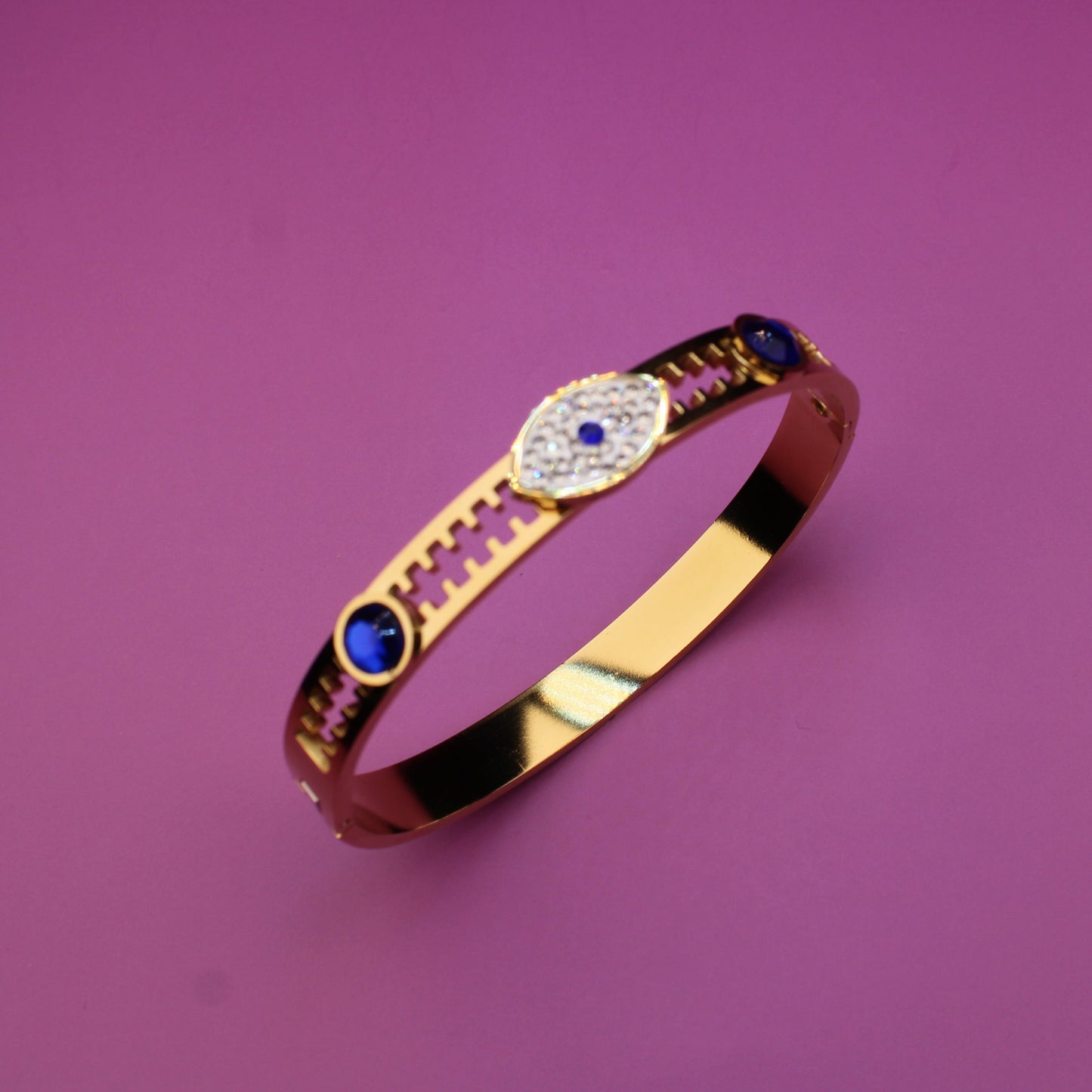 Gold bracelet with colorful stones on a purple background