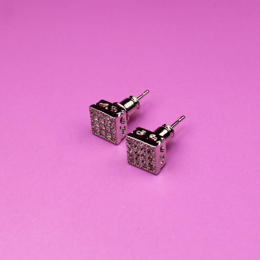 Pair of square stud earrings on a pink background
